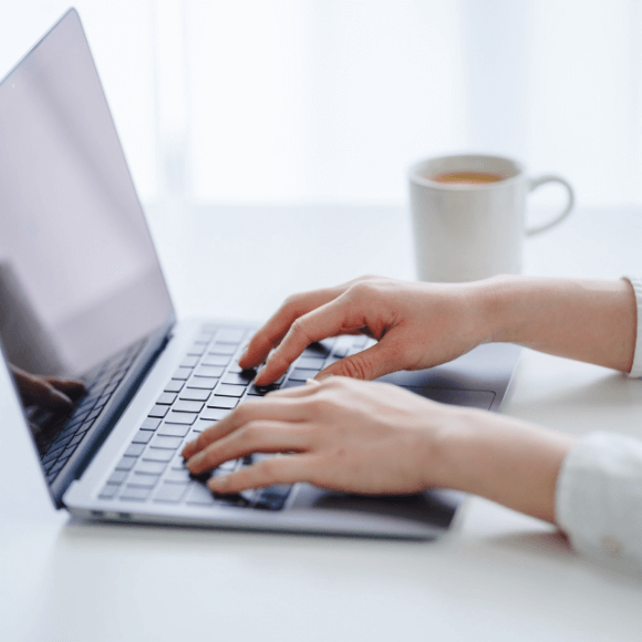 ノートパソコンを操作する手元の写真
